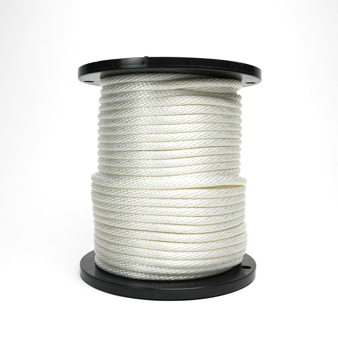 Spool of white rope on a black reel against a white background
