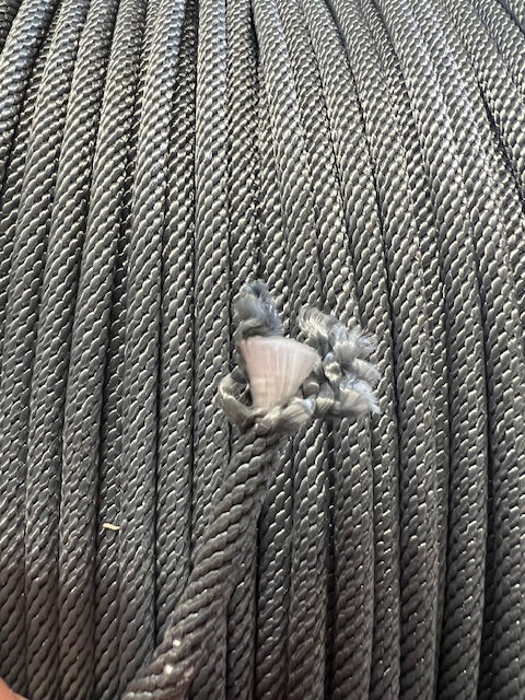 A close-up of a solid braid polyester pool cover rope.