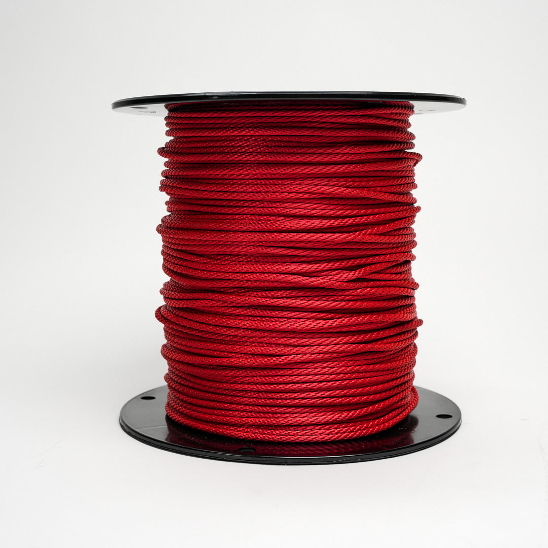 Spool of red rope on a white background