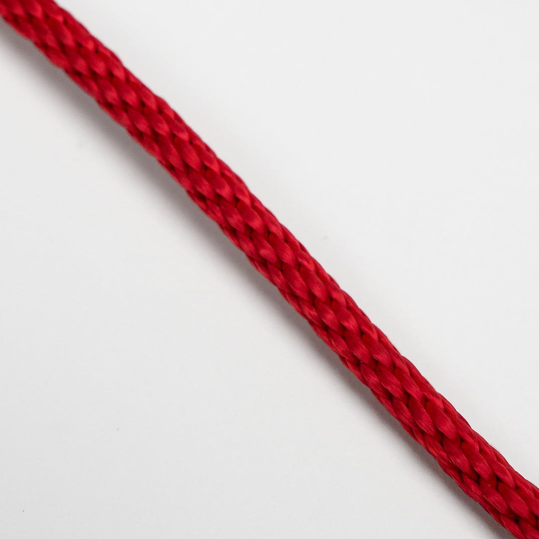 Close-up of a red braided cable on a light gray background